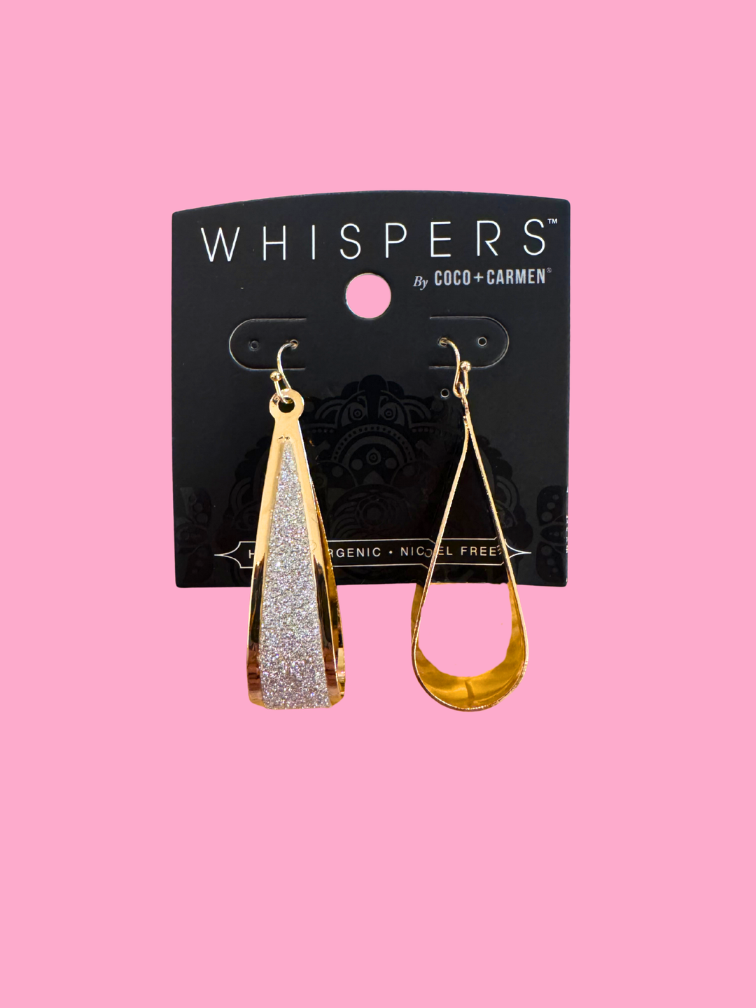 Gold and silver teardrop earrings on a 'Whispers' branded card against a pink background