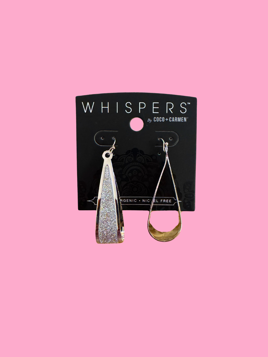 Pair of earrings on a 'Whispers' branded card against a pink background