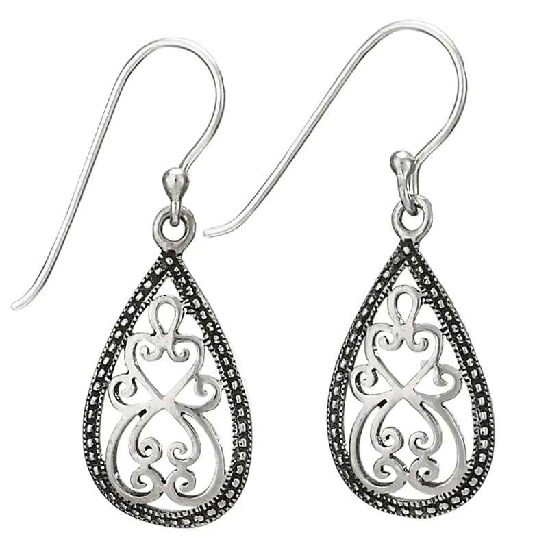 Pair of silver teardrop earrings with intricate designs on a white background
