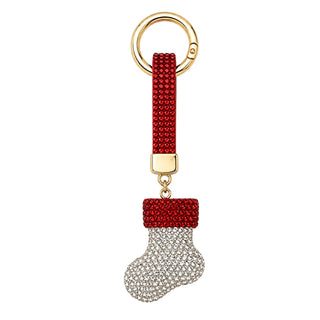 A Christmas stocking keychain featuring a red beaded strap and a stocking-shaped charm covered in clear rhinestones with a red beaded top, attached to a gold-tone split ring on a white background.
