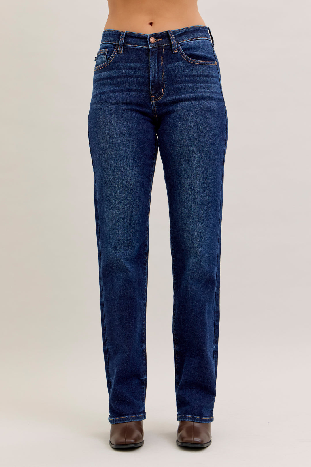 Blue jeans worn by a person on a plain background