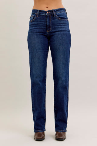 Blue jeans worn by a person on a plain background