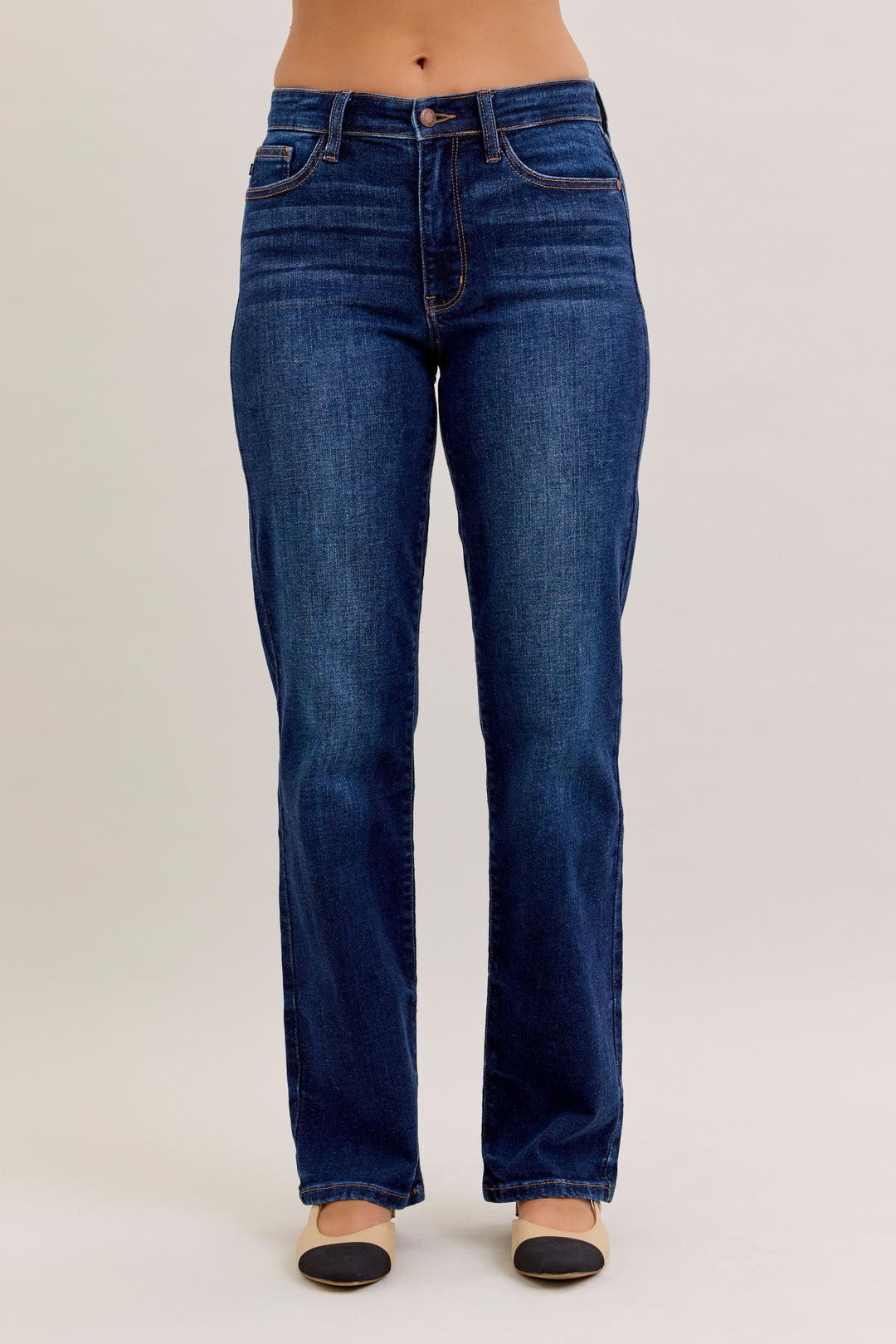 Blue jeans worn by a person on a plain background