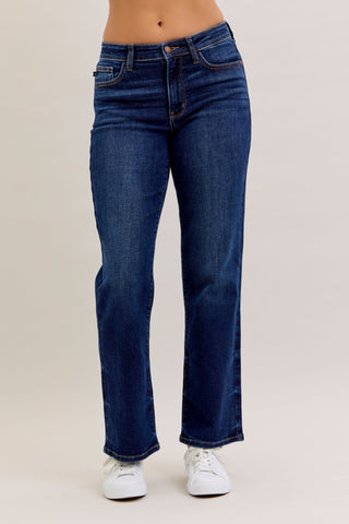 Blue jeans worn by a person on a beige background