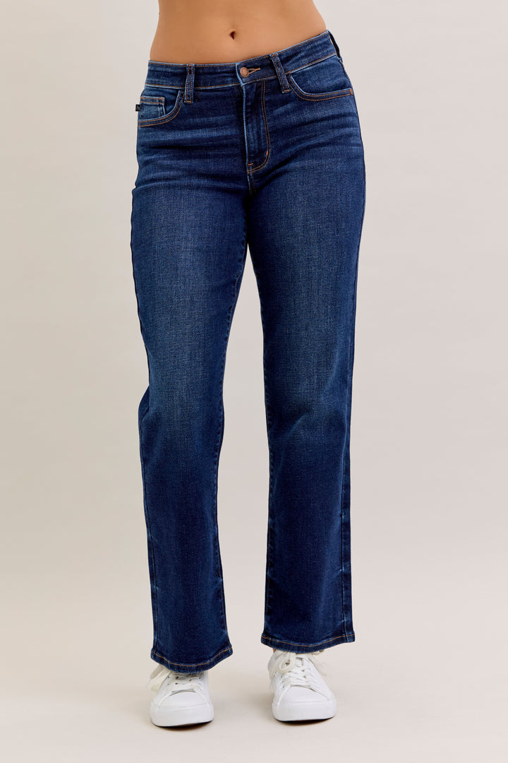 Blue jeans worn by a person on a beige background