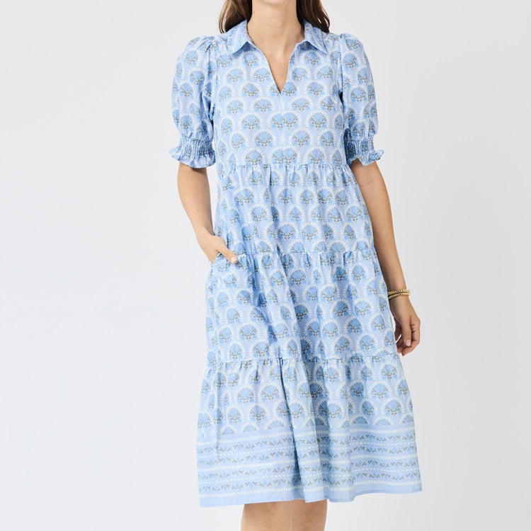 Woman wearing a blue patterned dress on a white background