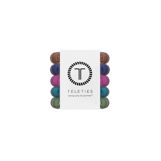 A pack of Teleties hair care caps with a white paper sleeve in the center featuring the brand logo and name, showing multiple colorful caps in different shades around the sleeve.