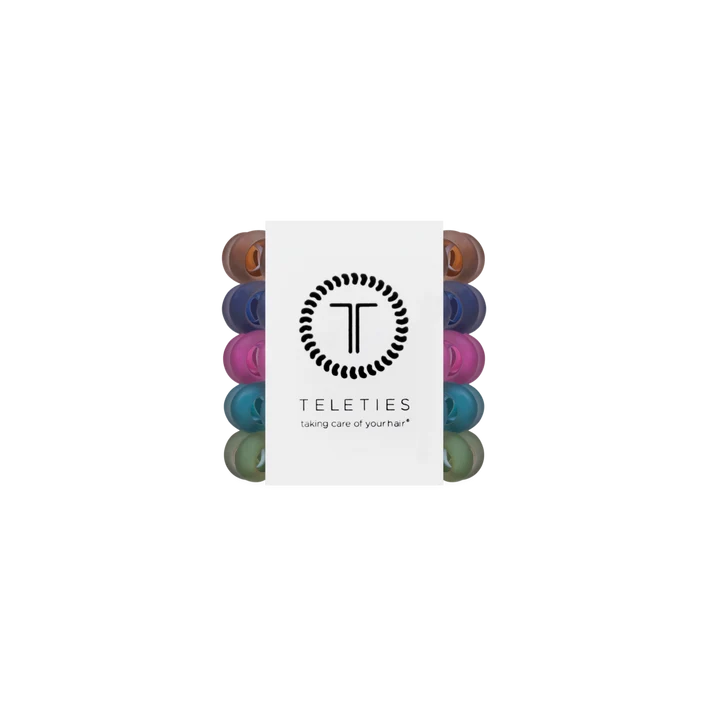 A pack of Teleties hair care caps with a white paper sleeve in the center featuring the brand logo and name, showing multiple colorful caps in different shades around the sleeve.