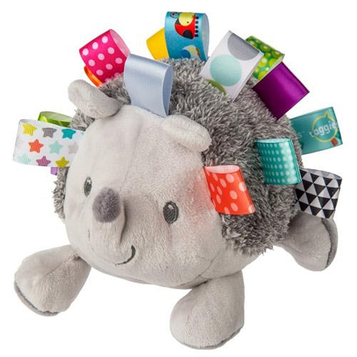 Plush hedgehog toy with colorful tags on a white background