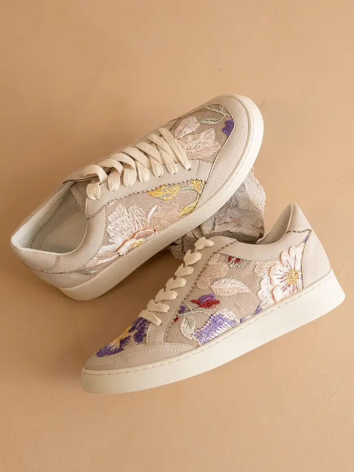 Pair of floral sneakers on a beige background