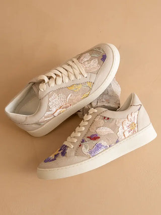 Pair of floral sneakers on a beige background
