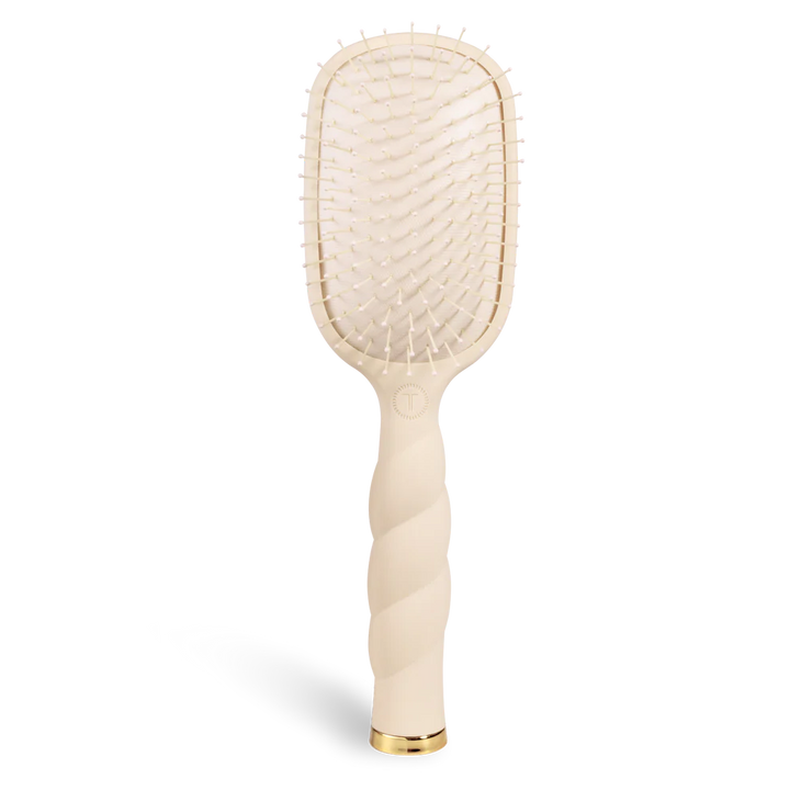 Beige paddle hairbrush on a white background
