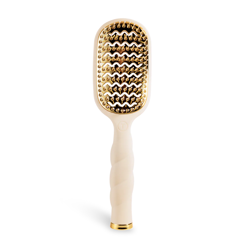 Hairbrush with gold bristle head and white handle on a white background