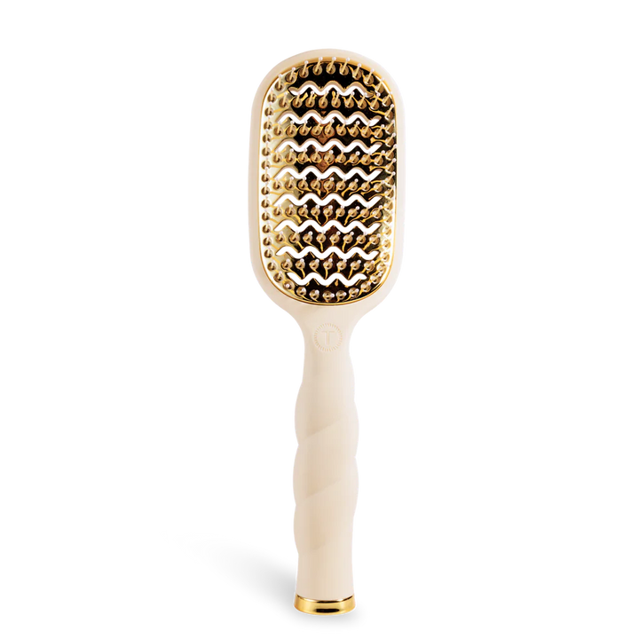 Hairbrush with gold bristle head and white handle on a white background