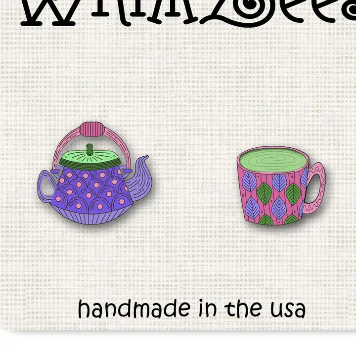 Two embroidered pins of a teapot and a mug on a white fabric background with 'handmade in the USA' text.