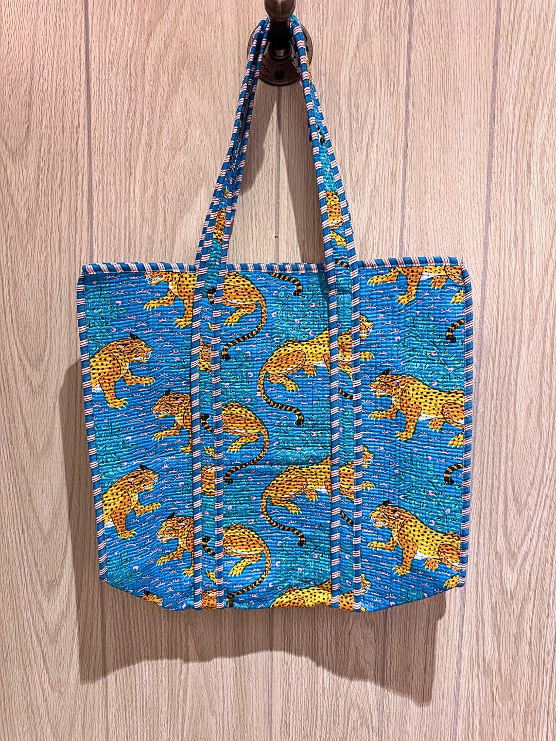 Tote bag with cheetah pattern on a wooden surface