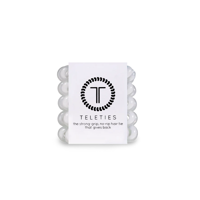 Pack of five white hair ties with the brand logo 'TELETIES' printed on the packaging, labeled as 'Coconut White' and stating 'The strong grips that give back'.
