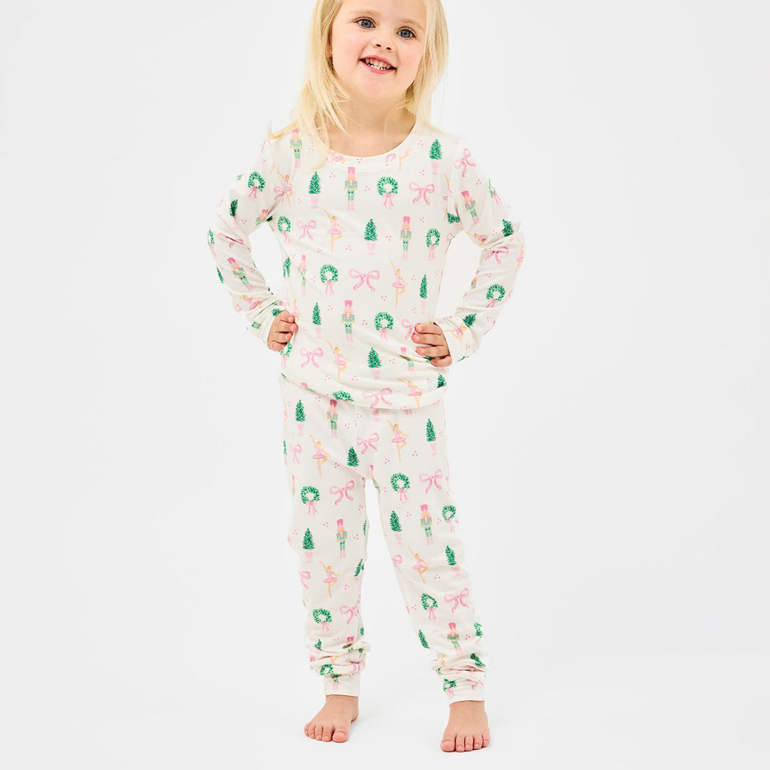 Child wearing a festive pajama set with Christmas-themed design on a white background