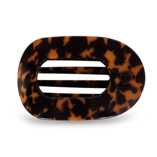 A flat round hair clip with a tortoise pattern design.