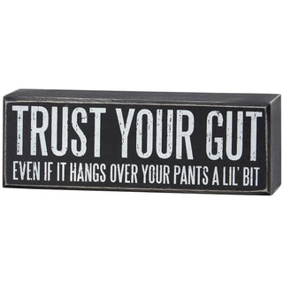 Black box sign with white text 'Trust Your Gut' on a white background
