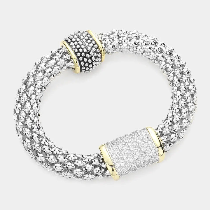 Silver bracelet with gold accents on a white background