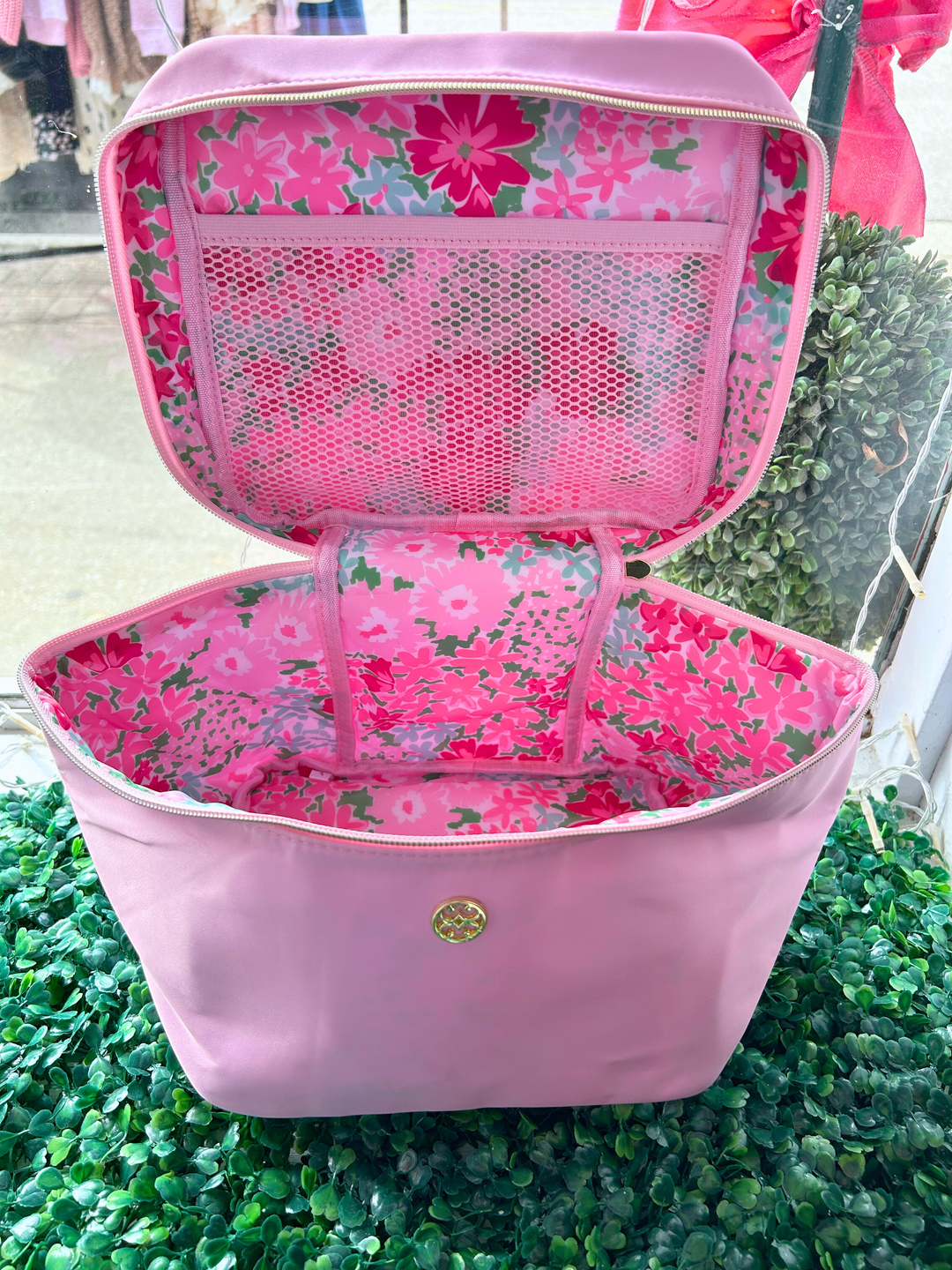 Pink bag with floral interior on a green grass background