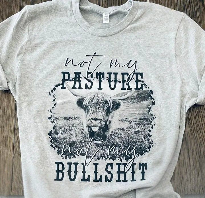 Grey heathered cotton tee with highland cow on front with the words Not my pasture not my bullshit