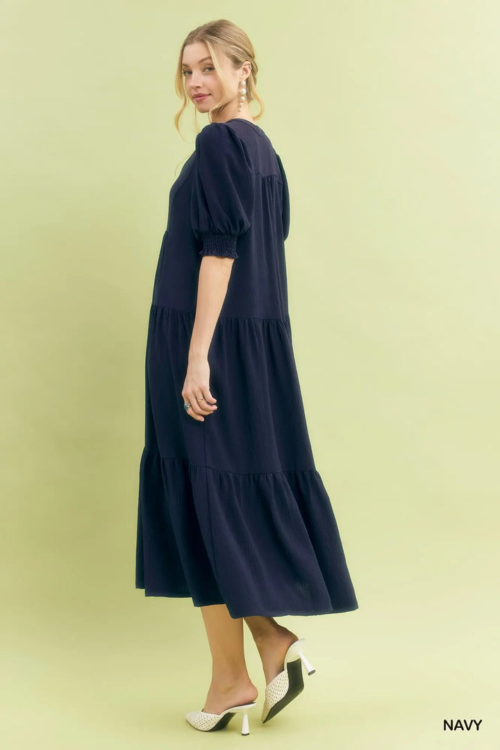 Woman wearing a navy blue dress on a light green background