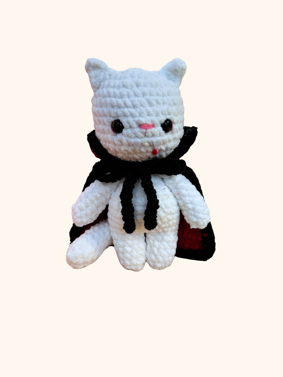 White crochet cat plush toy with black accents on a white background