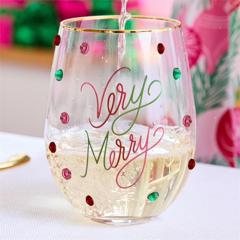 Stemless wine glass with 'Very Merry' text and colorful dots being filled with champagne.