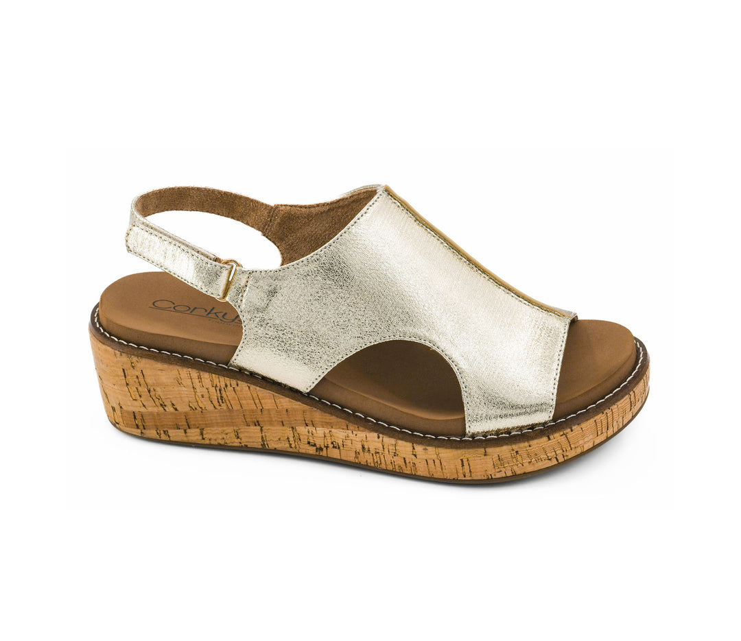 Gold wedge sandal with cork sole on a white background
