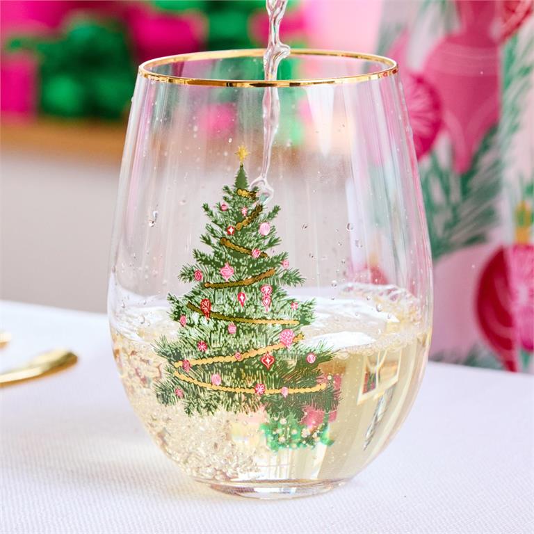 Decorative wine glass with a Christmas tree design being filled with white wine.