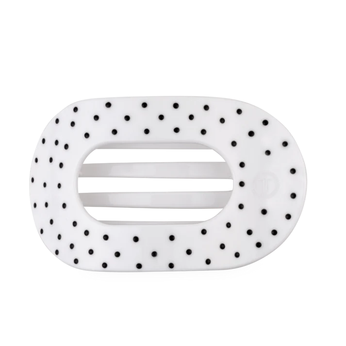 white oval shaped hair clip with black polka dots