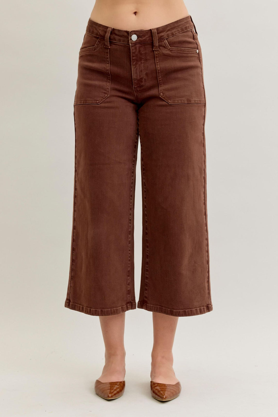Brown wide-leg jeans worn by a person on a plain background
