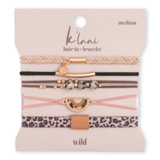 A set of five K'lani hair tie and bracelet elastic bands on a beige display card. The set includes a beige braided band, a black band with a gold bar and charm, thin brown bands with black-and-white speckled beads, a pink band with a gold crescent charm, and a leopard print band with a tan leather accent.