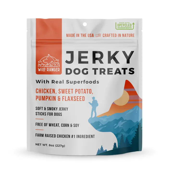 Wild Ranger Jerky Dog Treats in a 6 oz resealable stand-up pouch. The packaging is white with orange, black, and blue graphics, featuring a mountain and hiker illustration.