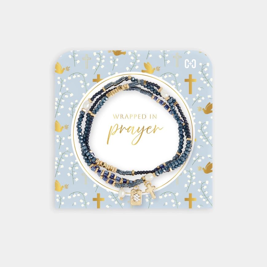 Set of beaded bracelets on a decorative card with 'Wrapped in Prayer' text