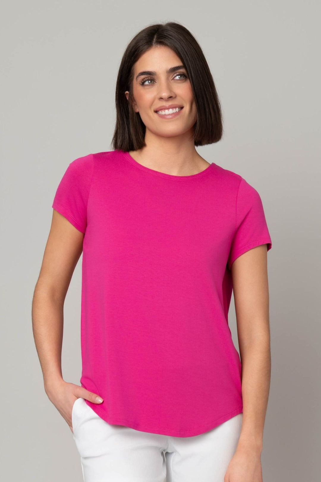 Woman wearing a bright pink t-shirt against a gray background