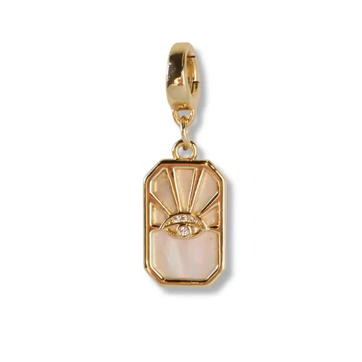 Gold pendant with a face design on a white background