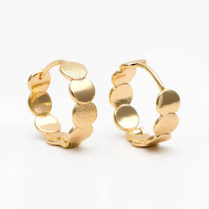 Gold hoop earrings with circular designs on a white background