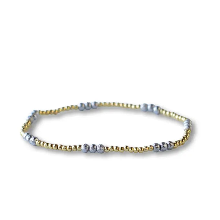 Bracelet with alternating gold and silver beads on a white background