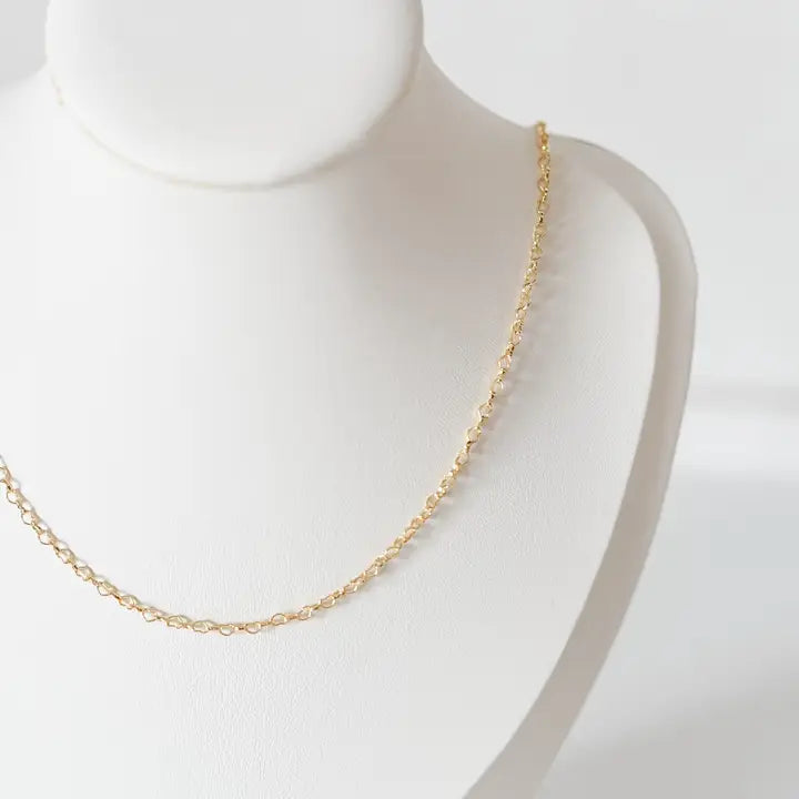 Gold chain necklace on a mannequin with a plain background