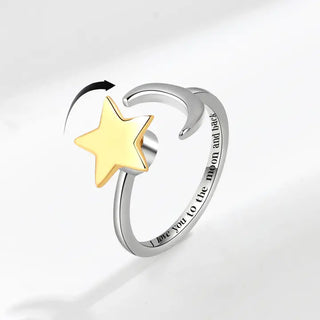A two-tone anxiety fidget spinner ring with a silver band and a gold-plated moon and star charm.
