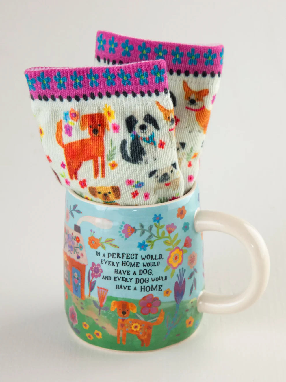 Mug with floral design and socks featuring dog illustrations on a white background