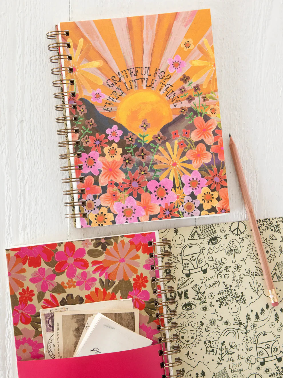 Colorful spiral-bound notebook with floral design on a white surface
