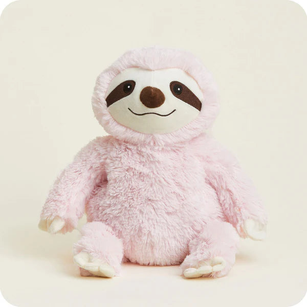 Pink plush sloth toy on a light beige background