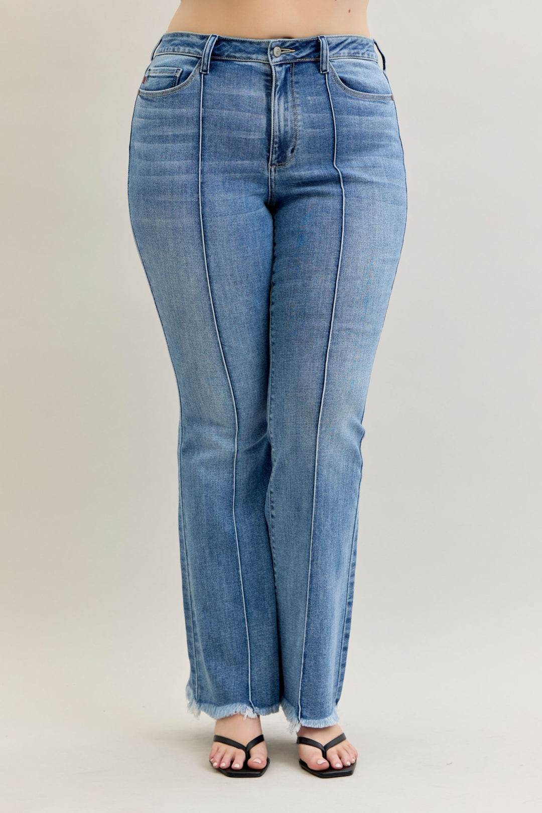 Blue jeans worn by a person on a plain background