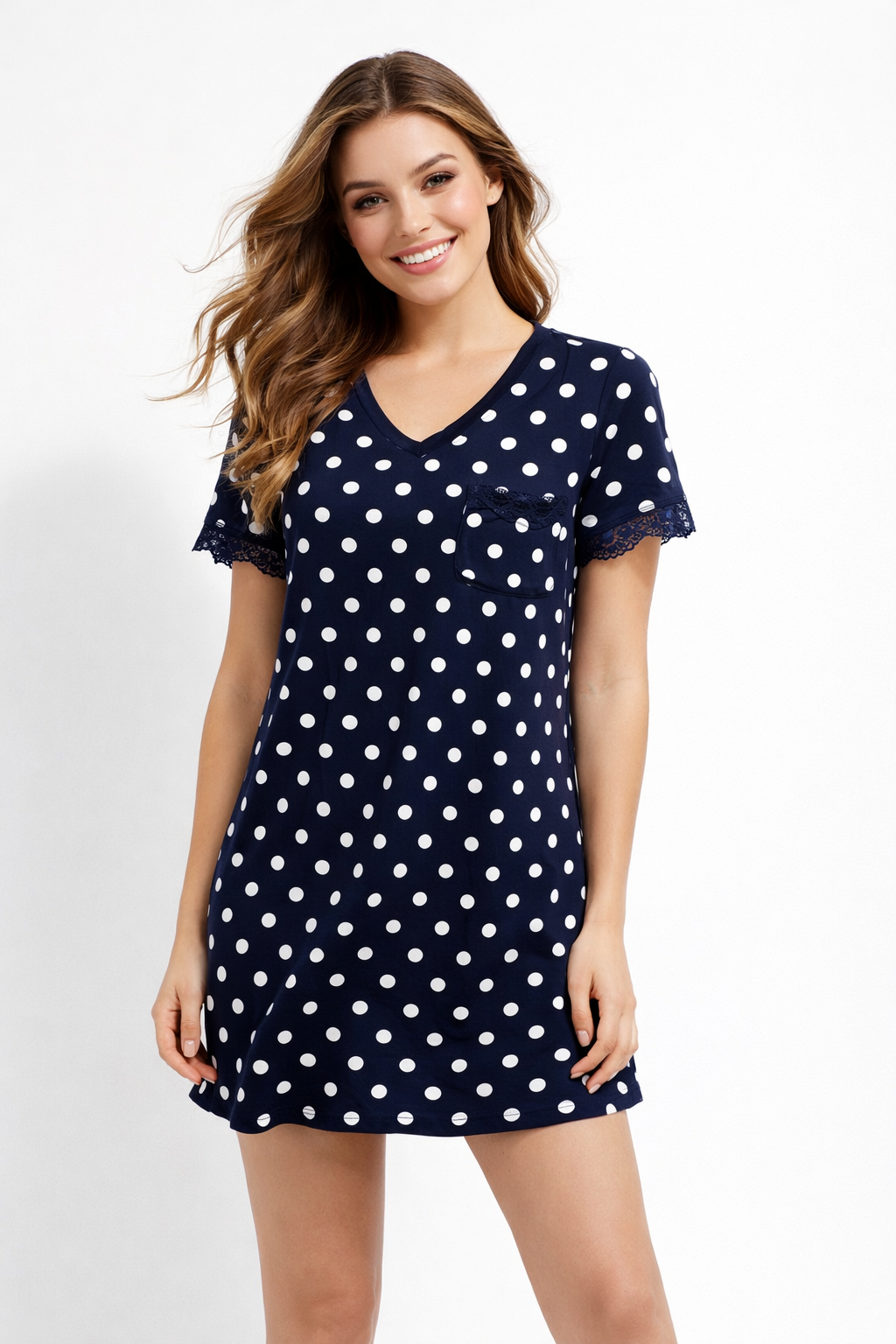 Woman wearing a navy blue nightshirt with white polka dots on a white background