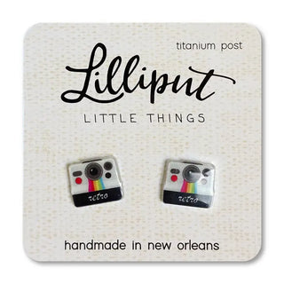 A pair of retro camera-shaped post earrings on a branded card, labeled 'Lilliput Little Things, handmade in New Orleans, LA'.