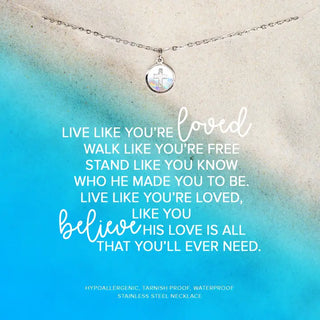 A sterling silver necklace with a seashell-shaped cross charm, displayed against a blue and white background with text lyrics.